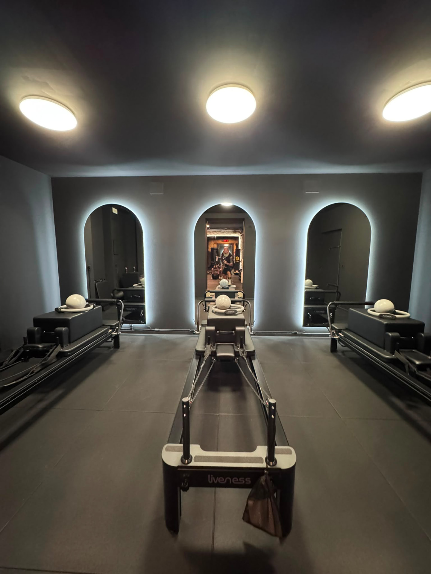 Sala Pilates Reformer con specchi ad arco illuminati nello studio U-Change